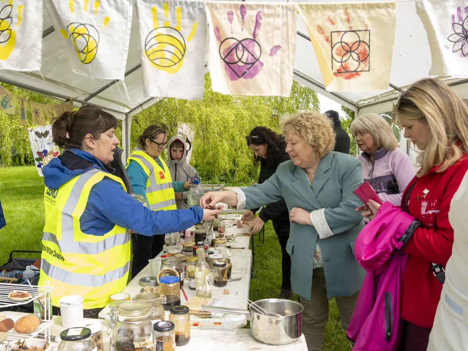Volunteers in high-vis vests helping visitors at an outdoor community event